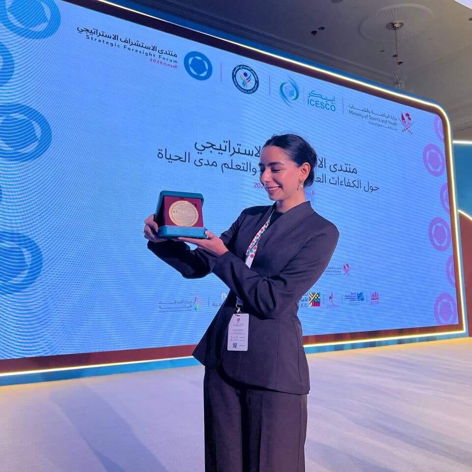 Shakhzoda Ikromova holding the opened commemorative plaque in front of the Strategic Foresight Forum screen.